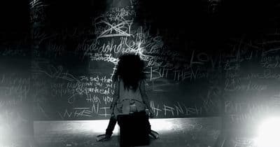 a woman standing in front of a wall covered in graffiti