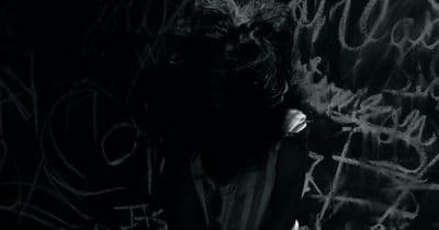a man standing in front of a wall covered in graffiti