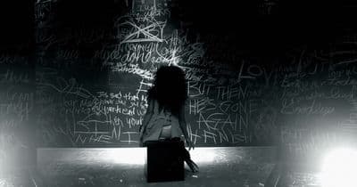 a woman standing in front of a wall covered in graffiti