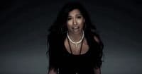 a woman in a black dress with a necklace on