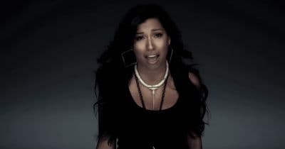 a woman in a black dress with a necklace on