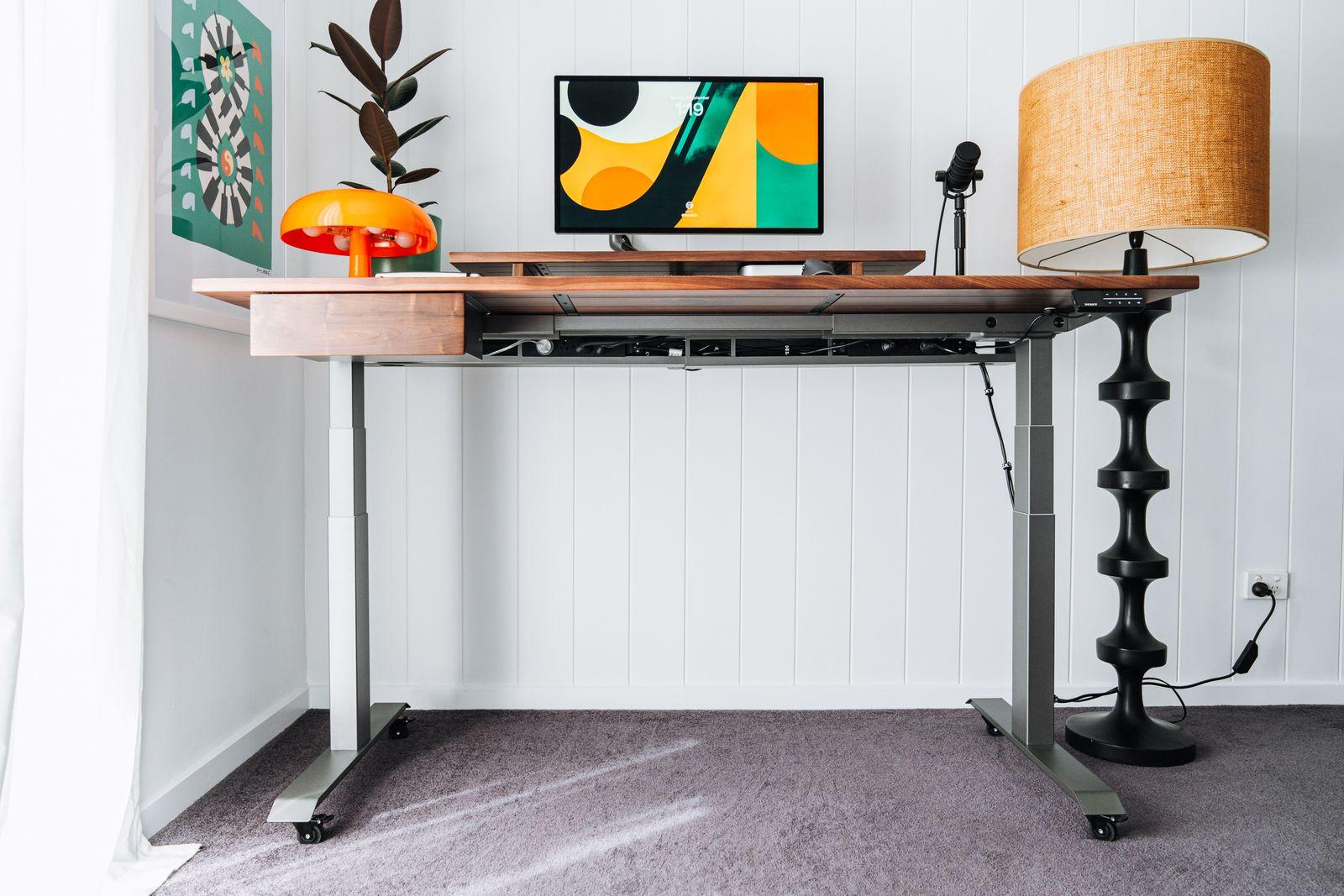 a desk with a lamp and a picture on it