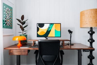 a desk with a computer and a lamp on it