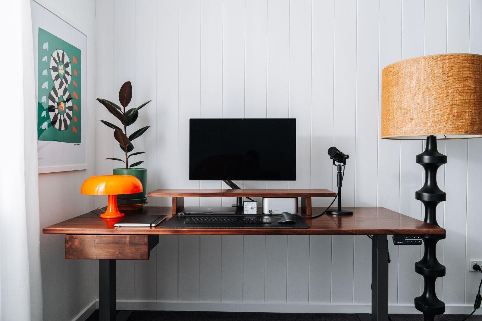 a desk with a computer and a lamp on it