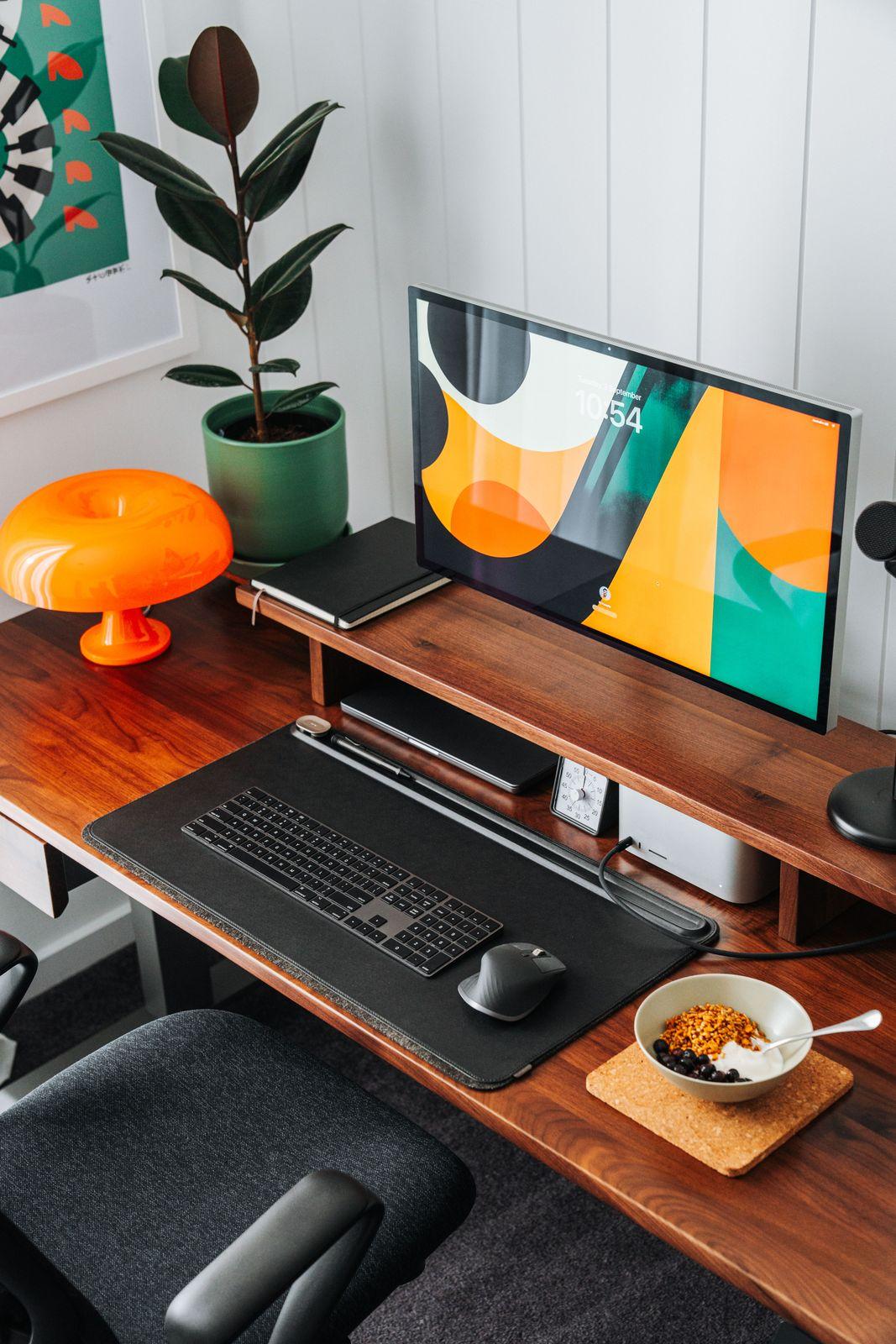 a desk with a computer and a bowl of cereal on it