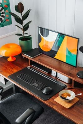 a desk with a computer and a bowl of cereal on it