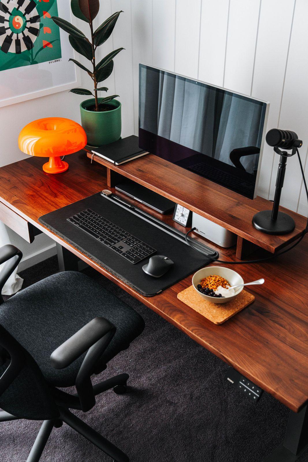 a desk with a computer and a bowl of cereal