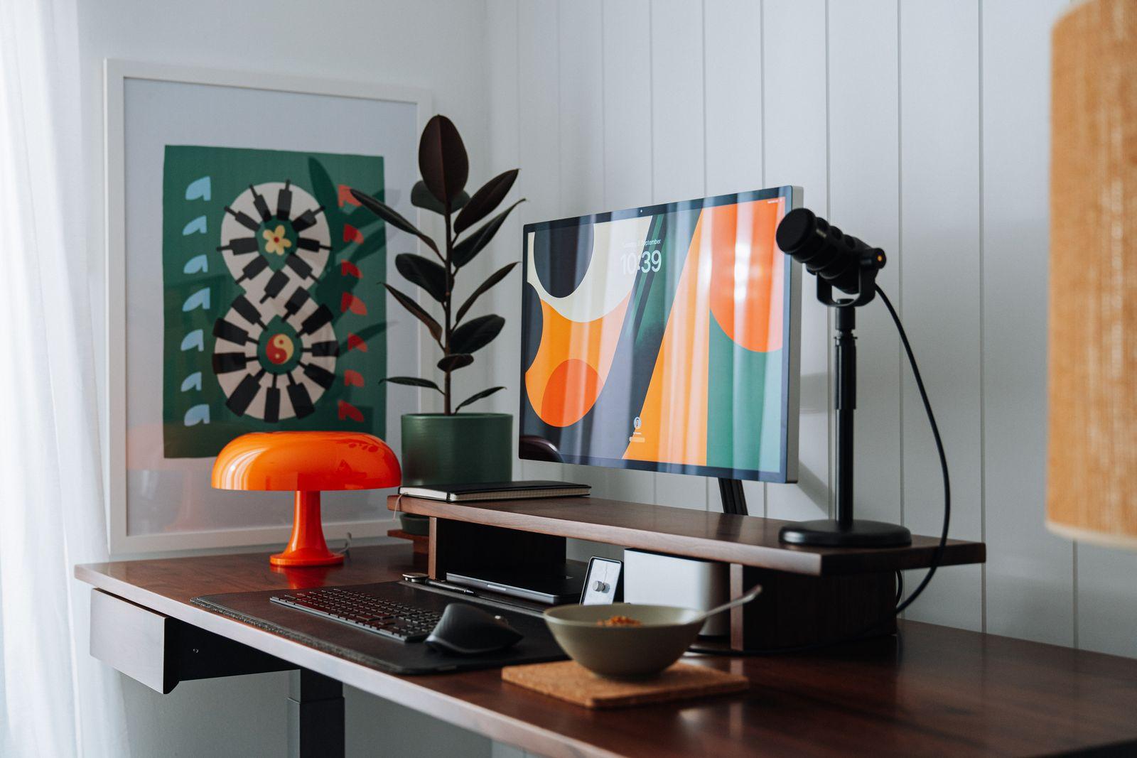 a desk with a computer and a lamp on it