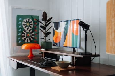 a desk with a computer and a lamp on it
