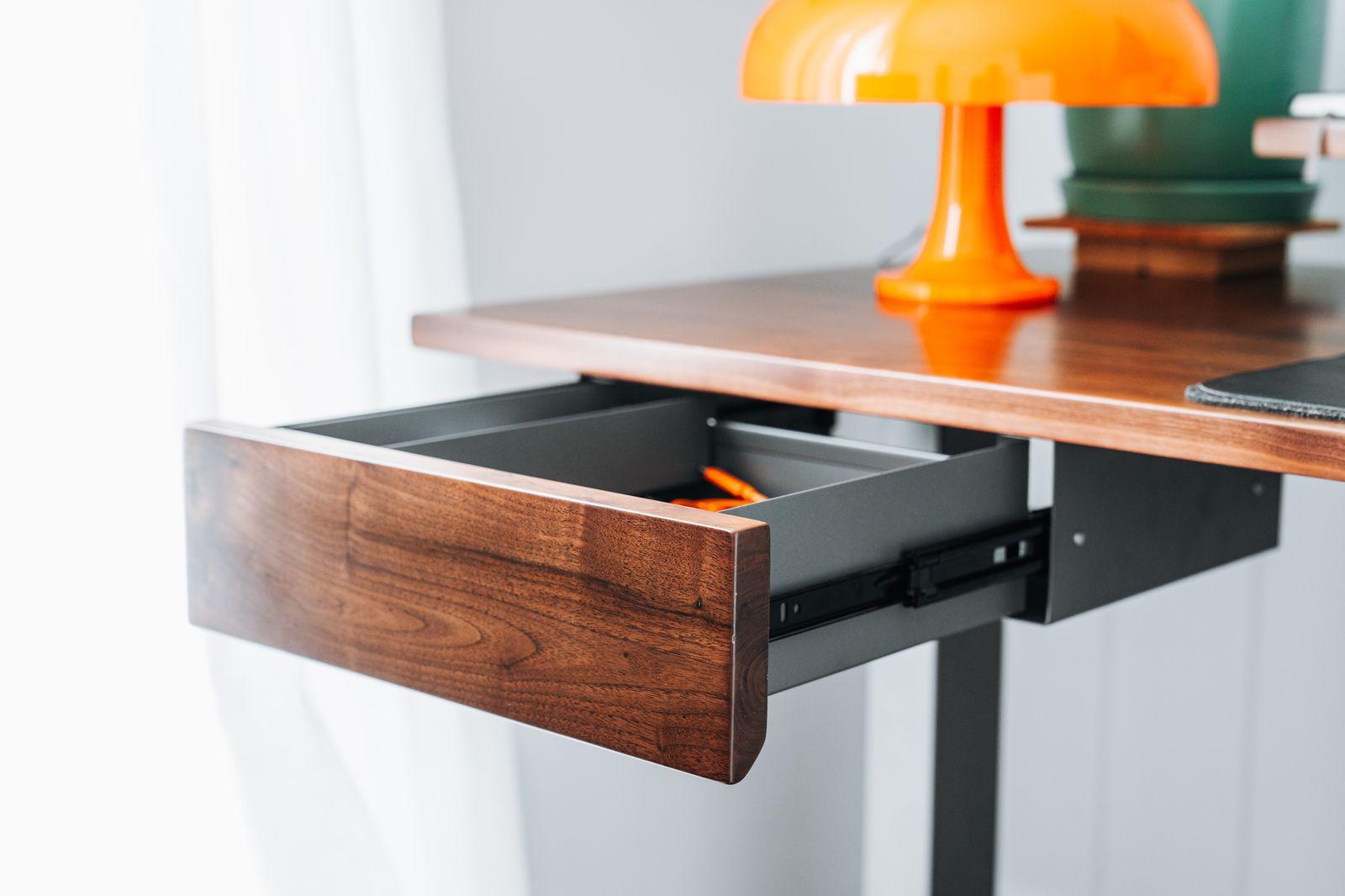 a desk with a laptop and a lamp on it
