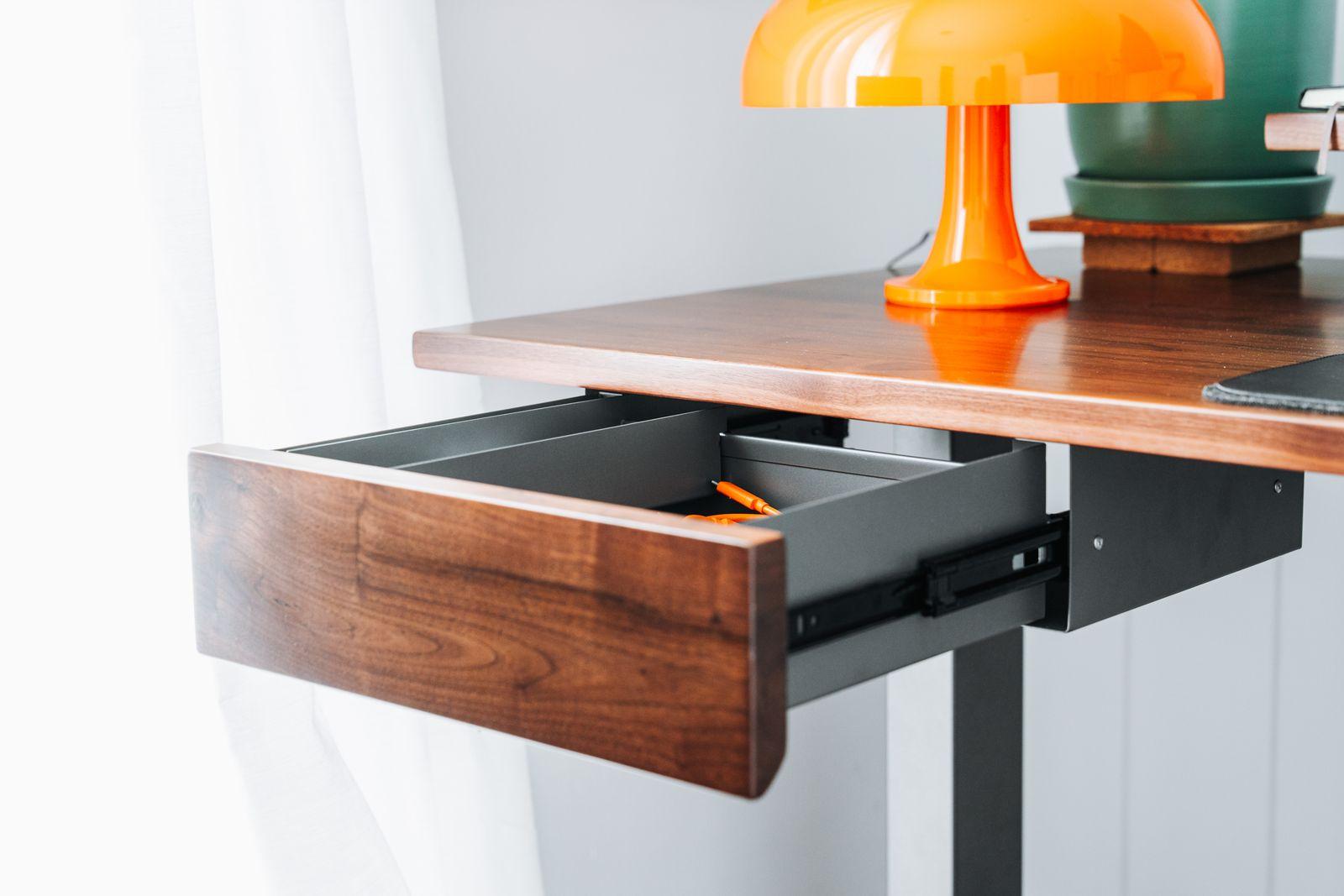 a desk with a laptop and a lamp on it