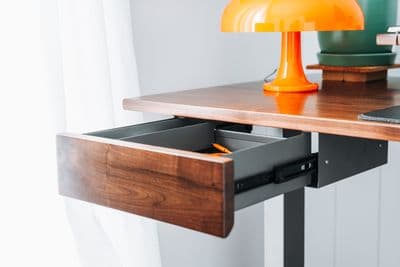 a desk with a laptop and a lamp on it