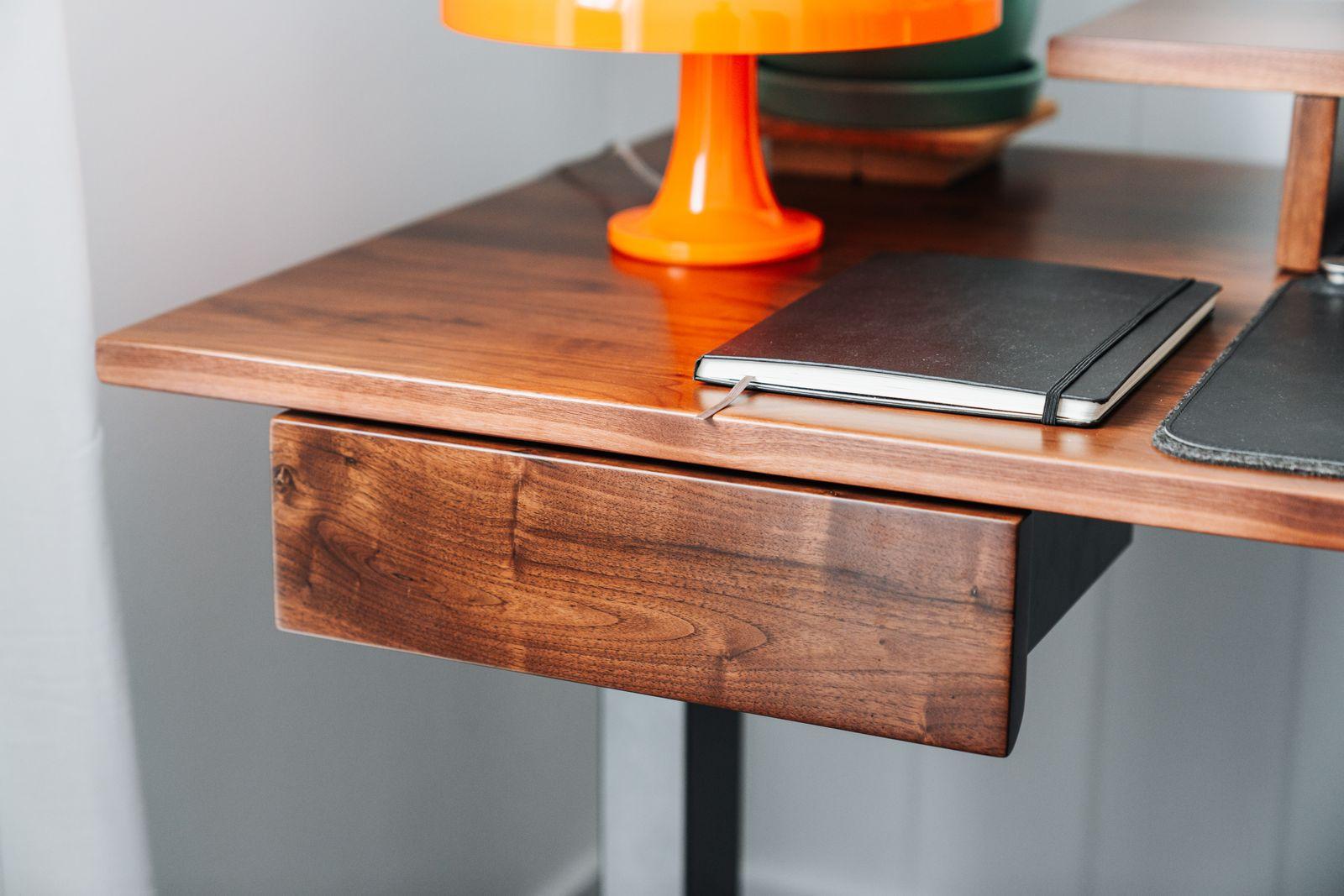 a desk with a laptop and a lamp on it