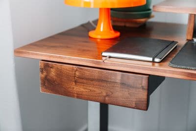 a desk with a laptop and a lamp on it