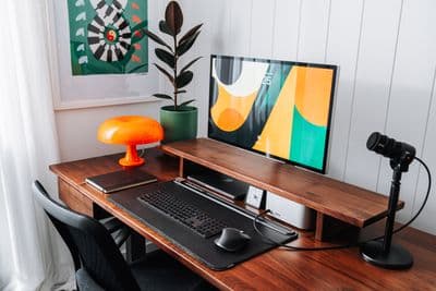 a desk with a computer monitor, keyboard and mouse