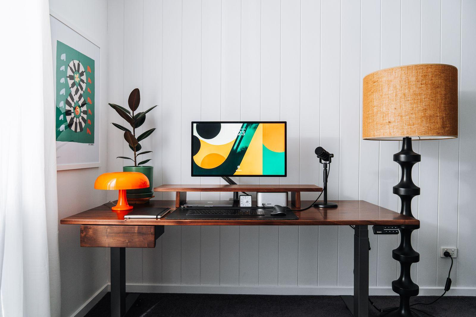 a desk with a lamp and a computer on it