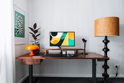 a desk with a lamp and a computer on it