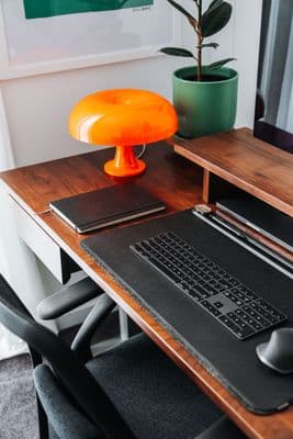 a desk with a laptop and a lamp on it