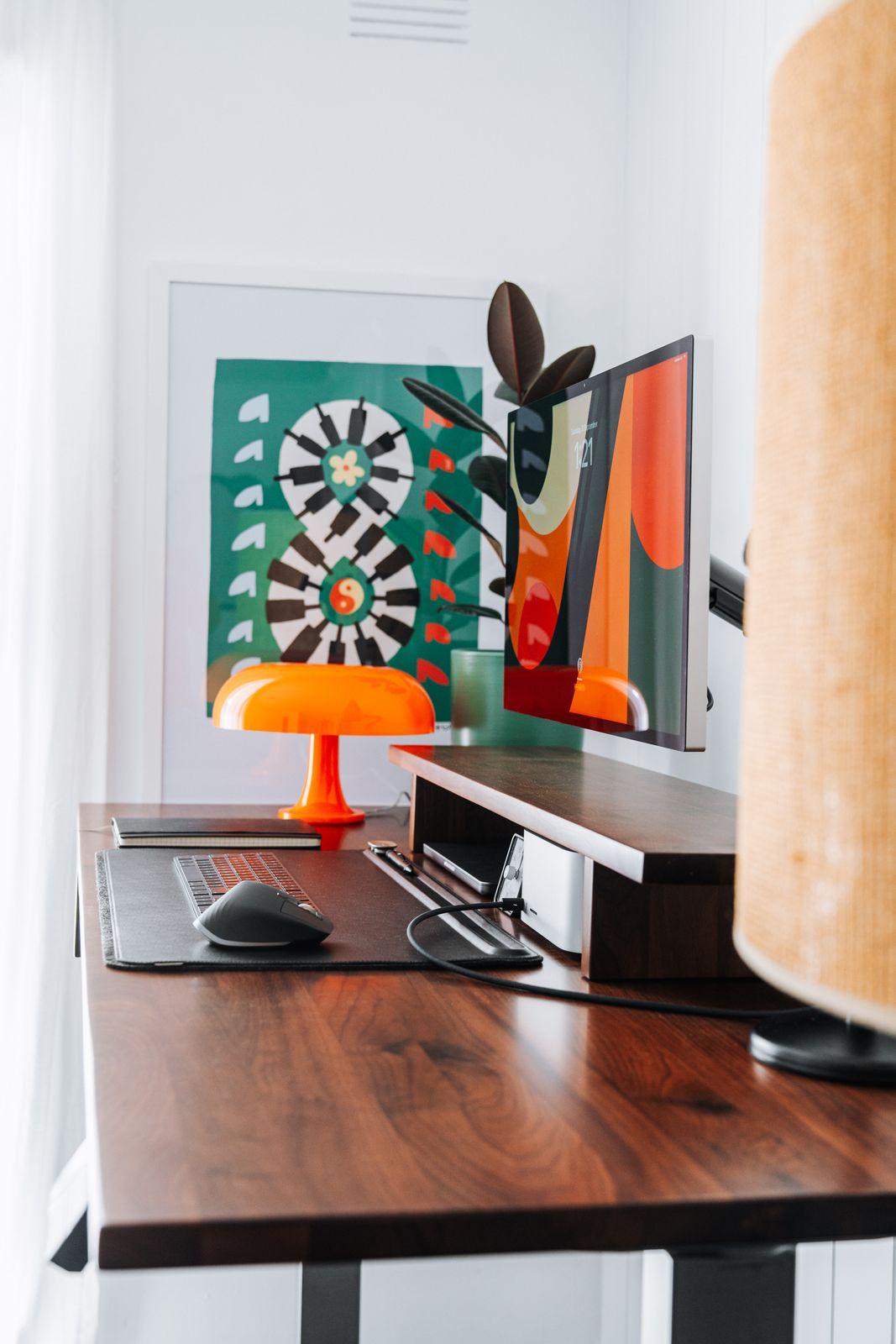 a desk with a computer and a lamp on it