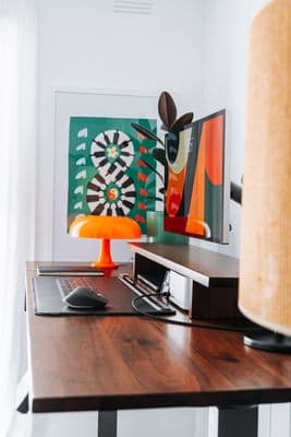 a desk with a computer and a lamp on it