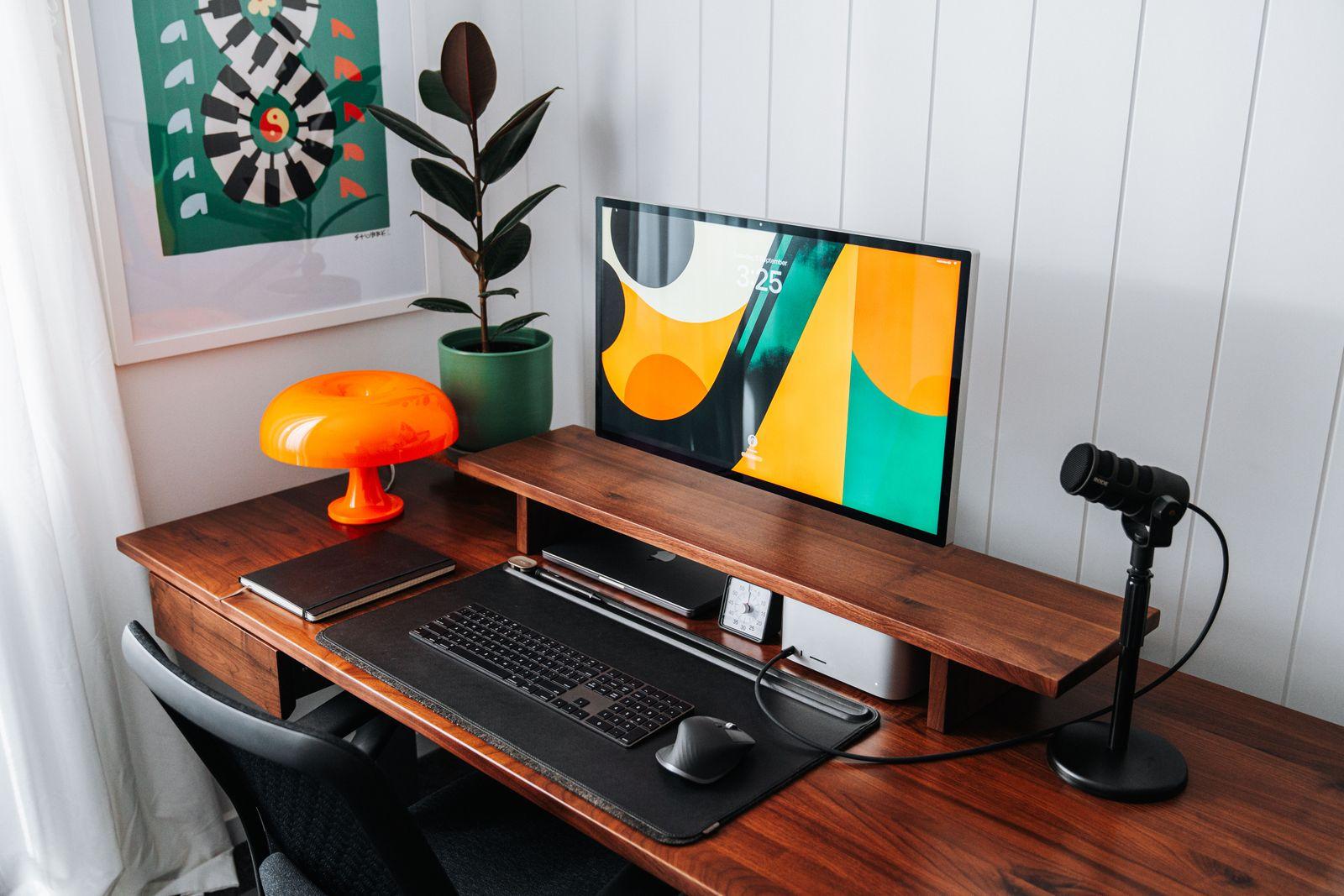 a desk with a computer and a lamp on it