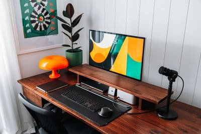 a desk with a computer and a lamp on it