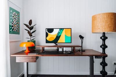 a desk with a computer and a lamp on it