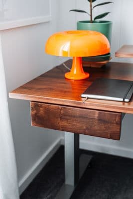a desk with a laptop and a lamp on it