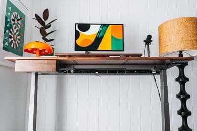 a desk with a lamp and a picture on it
