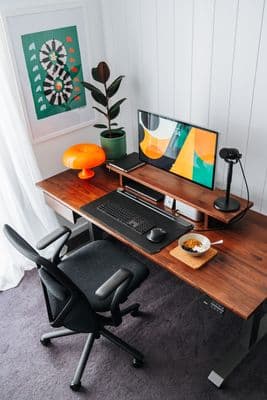 a desk with a computer and a bowl of food on it