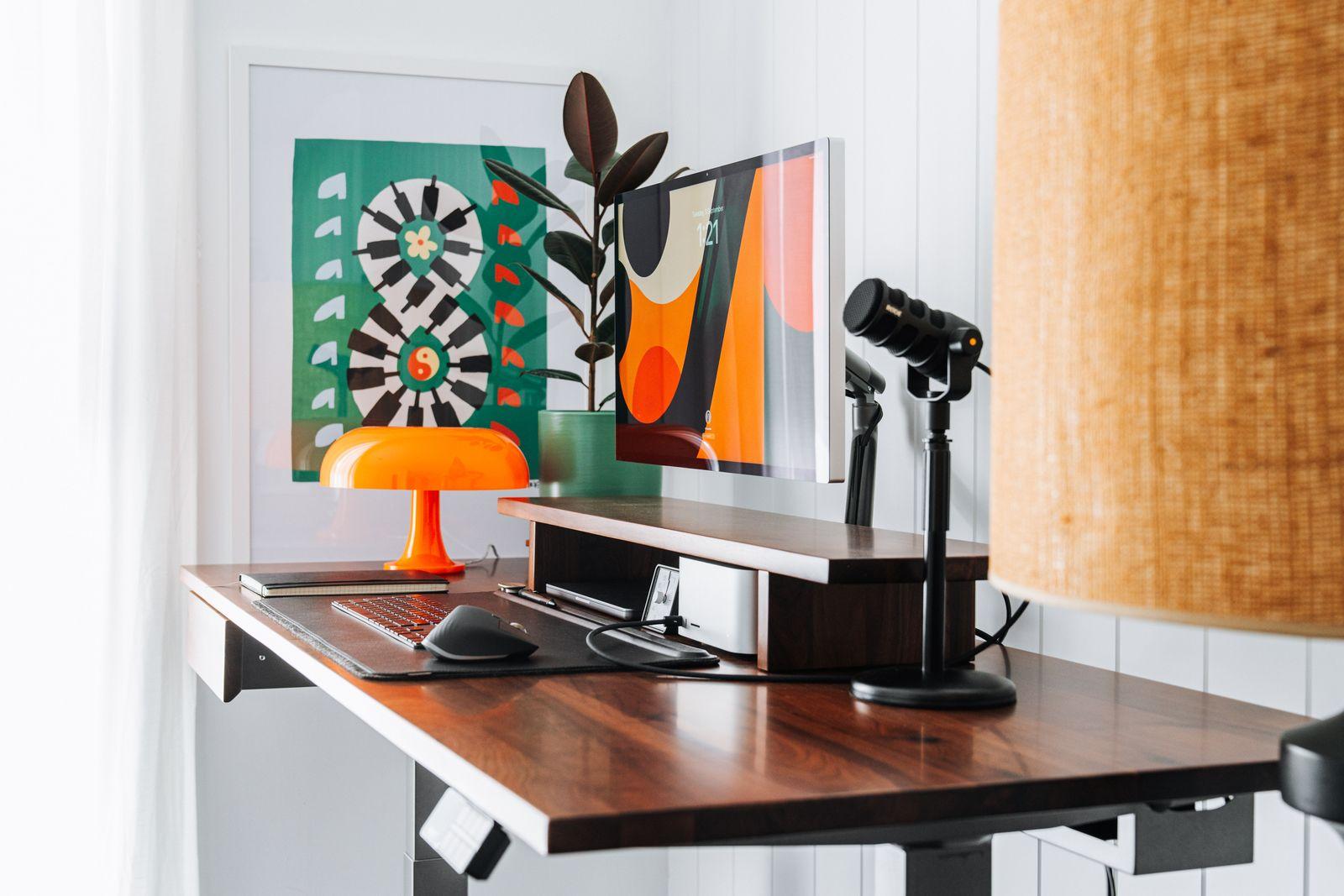 a desk with a lamp and a laptop on it