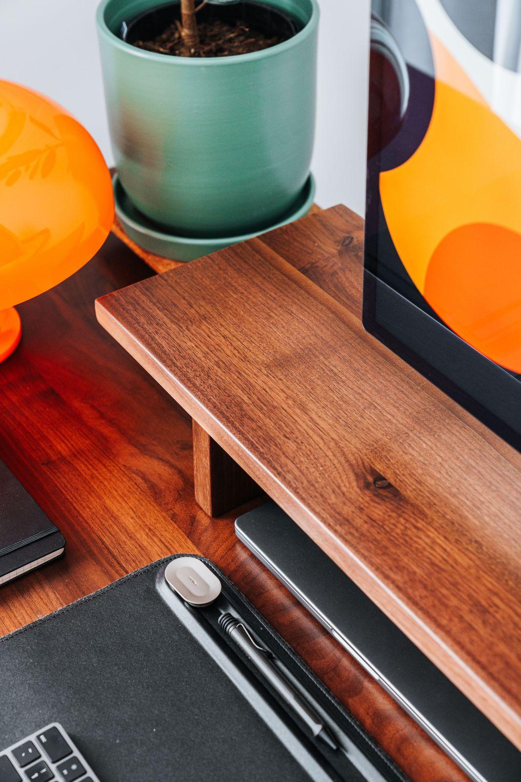a wooden table topped with a laptop computer next to a potted plant