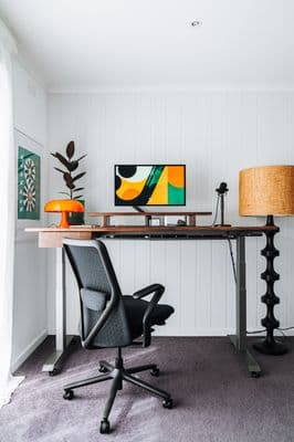 a desk with a chair and a lamp in a room