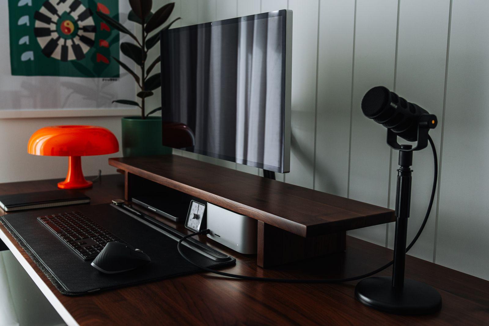 a desk with a laptop, mouse and a lamp on it