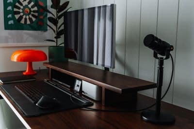 a desk with a laptop, mouse and a lamp on it