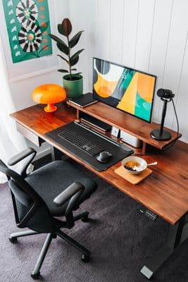 a computer desk with a monitor, keyboard and mouse