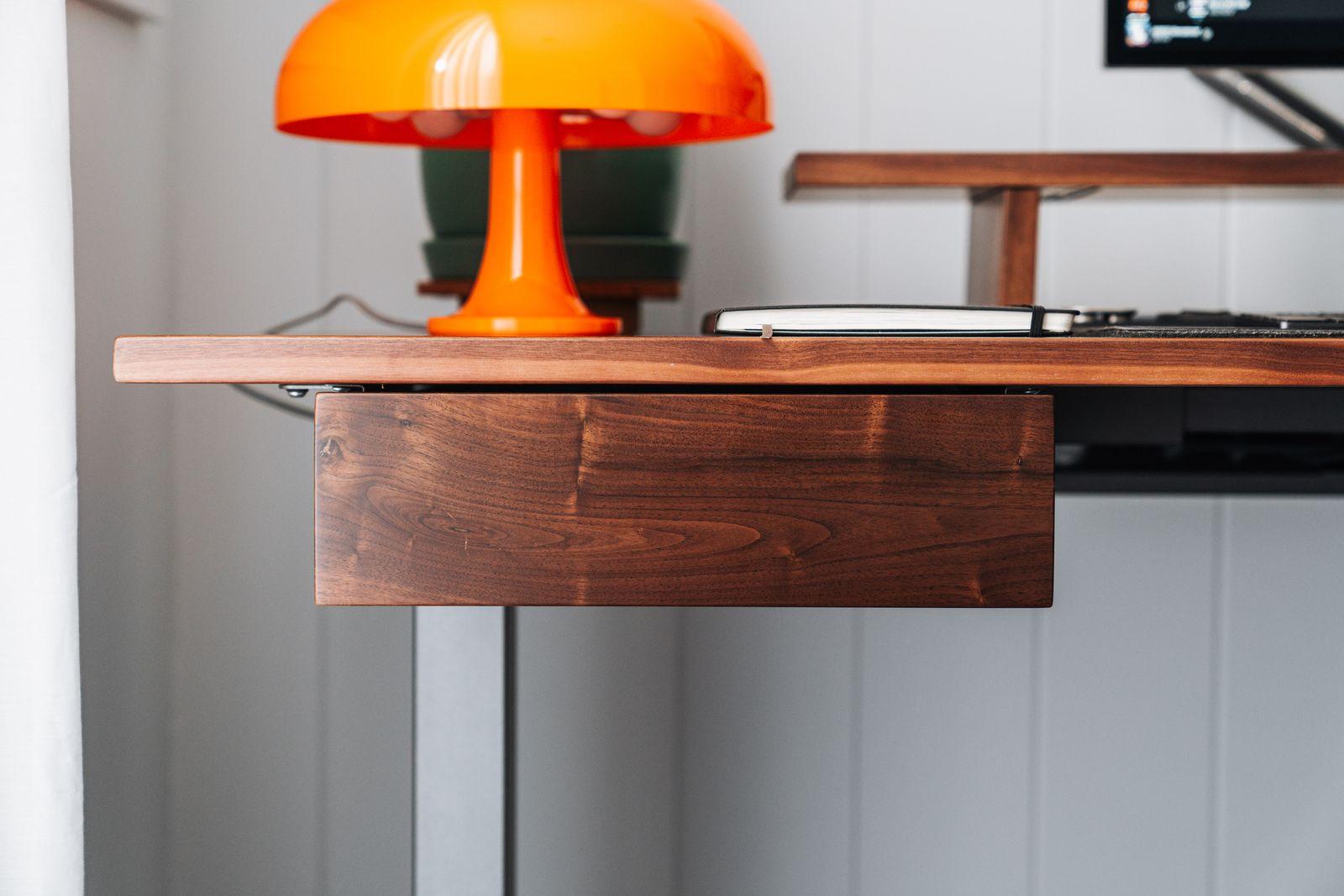 a desk with a lamp and a laptop on it
