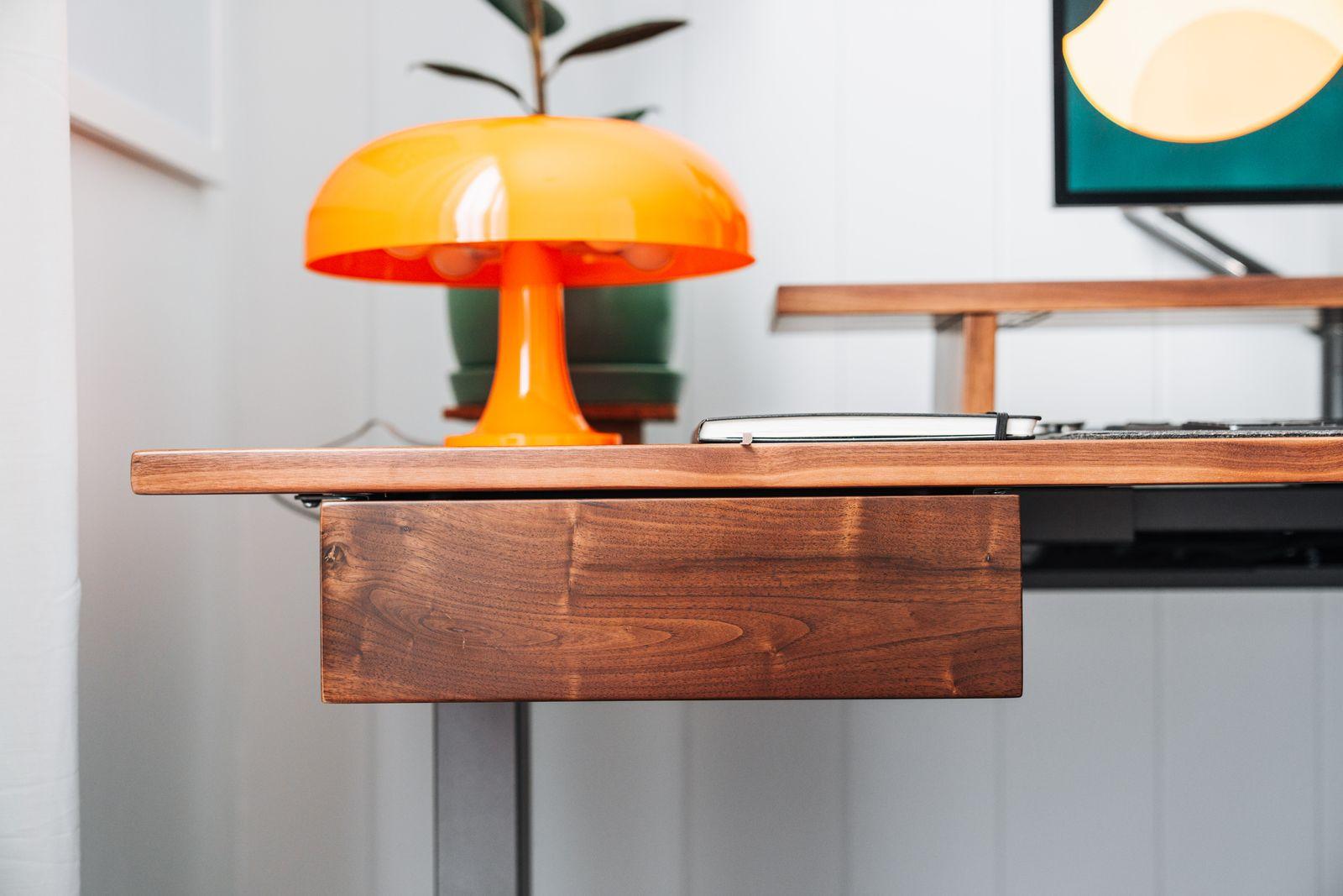 a desk with a lamp and a laptop on it