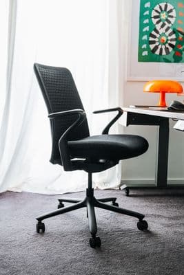 a black office chair sitting in front of a desk