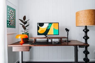 a desk with a computer and a lamp on it