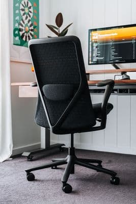 a black office chair sitting in front of a computer monitor