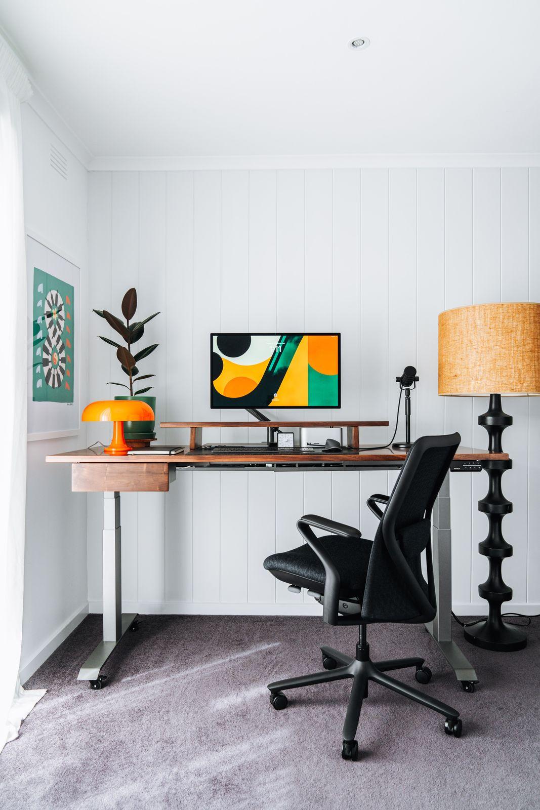a desk with a chair and a lamp in a room