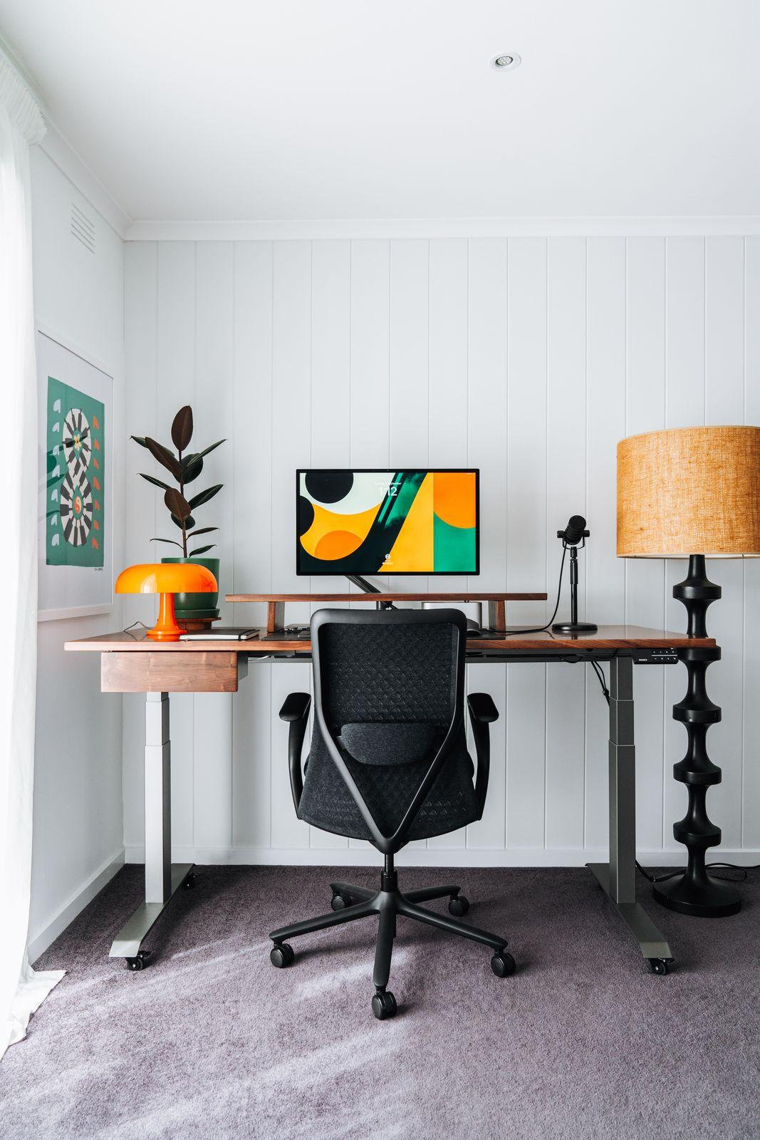 a desk with a chair and a lamp in a room
