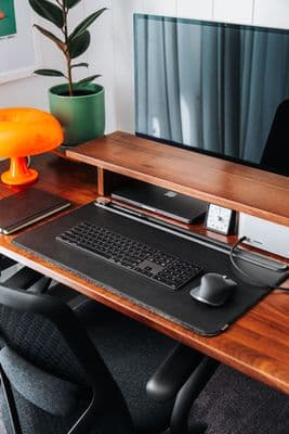 a computer desk with a keyboard and mouse