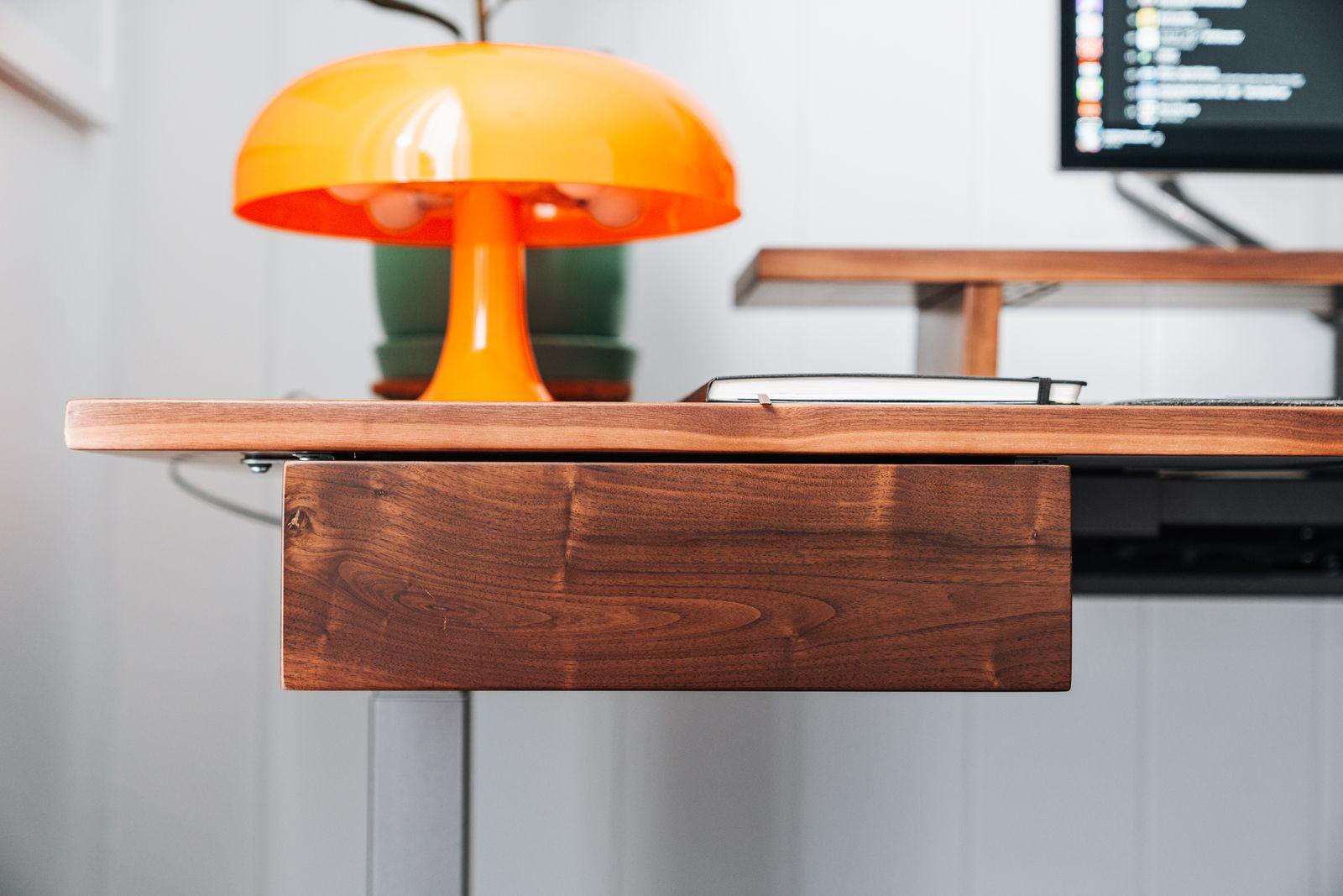 a desk with a lamp and a laptop on it