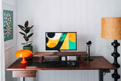 a desk with a computer and a lamp on it
