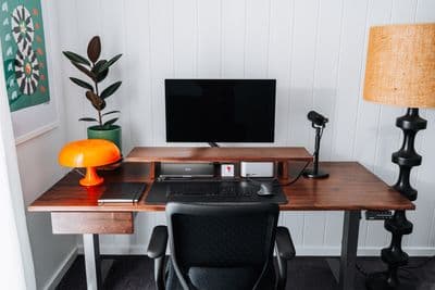 a desk with a computer and a lamp on it