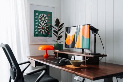 a desk with a computer and a lamp on it