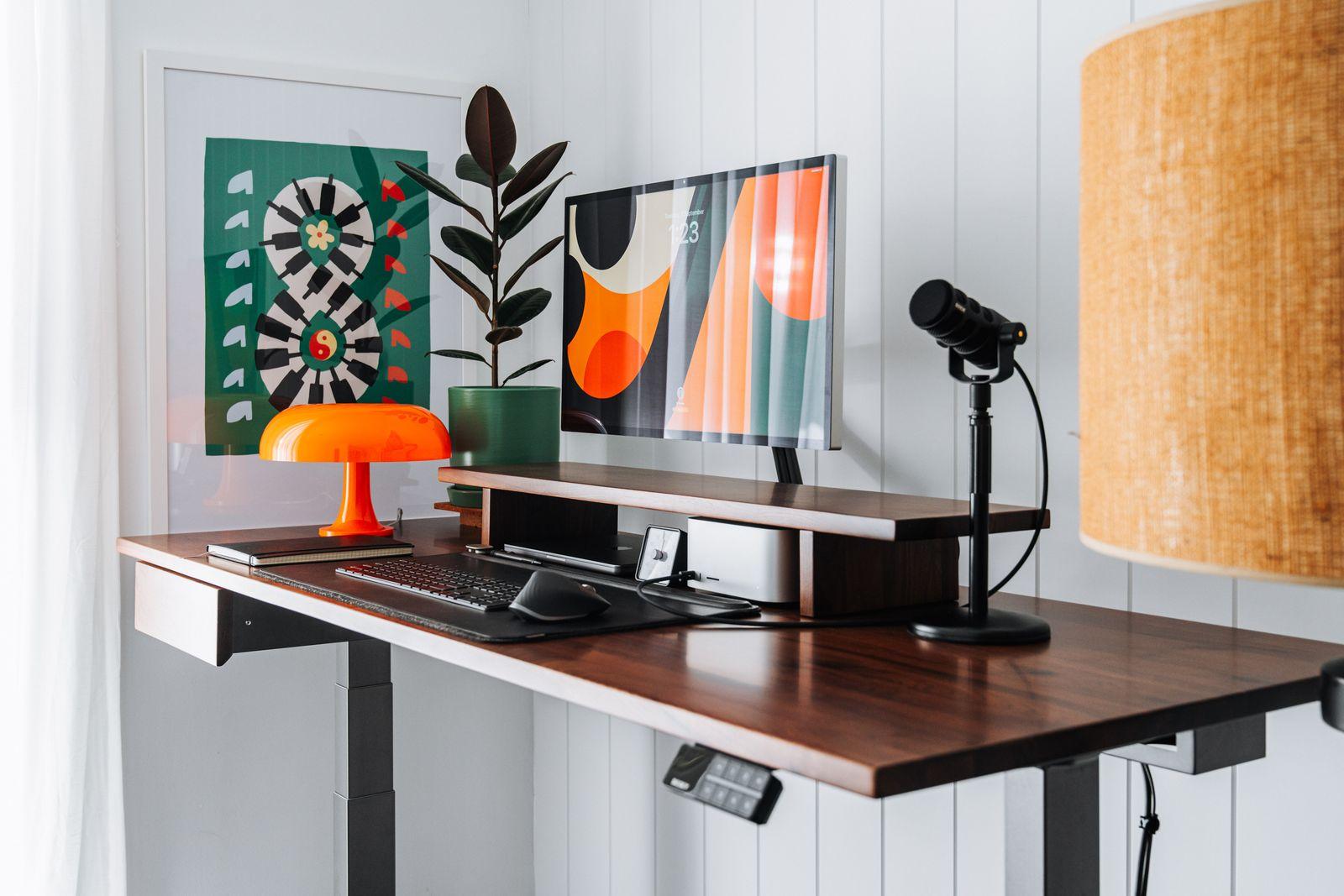 a desk with a lamp and a computer on it