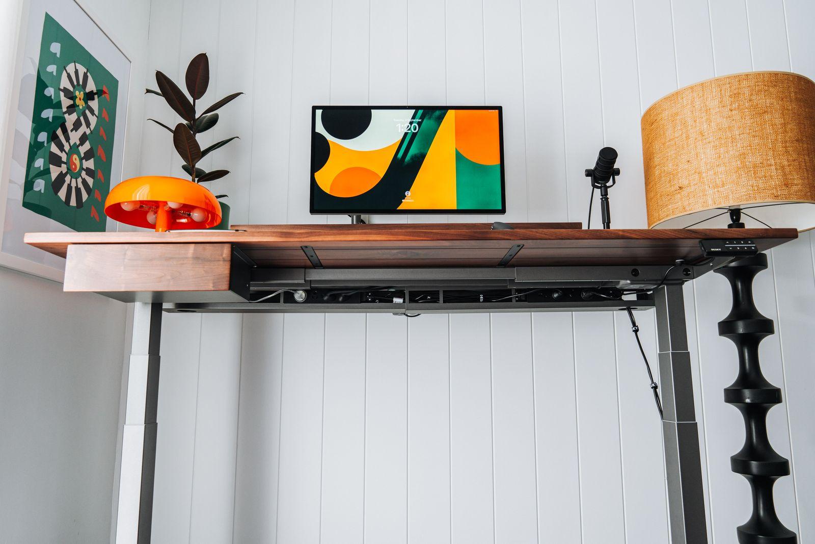 a desk with a lamp and a painting on it
